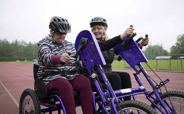 Photo of 2 people cycling side by side.