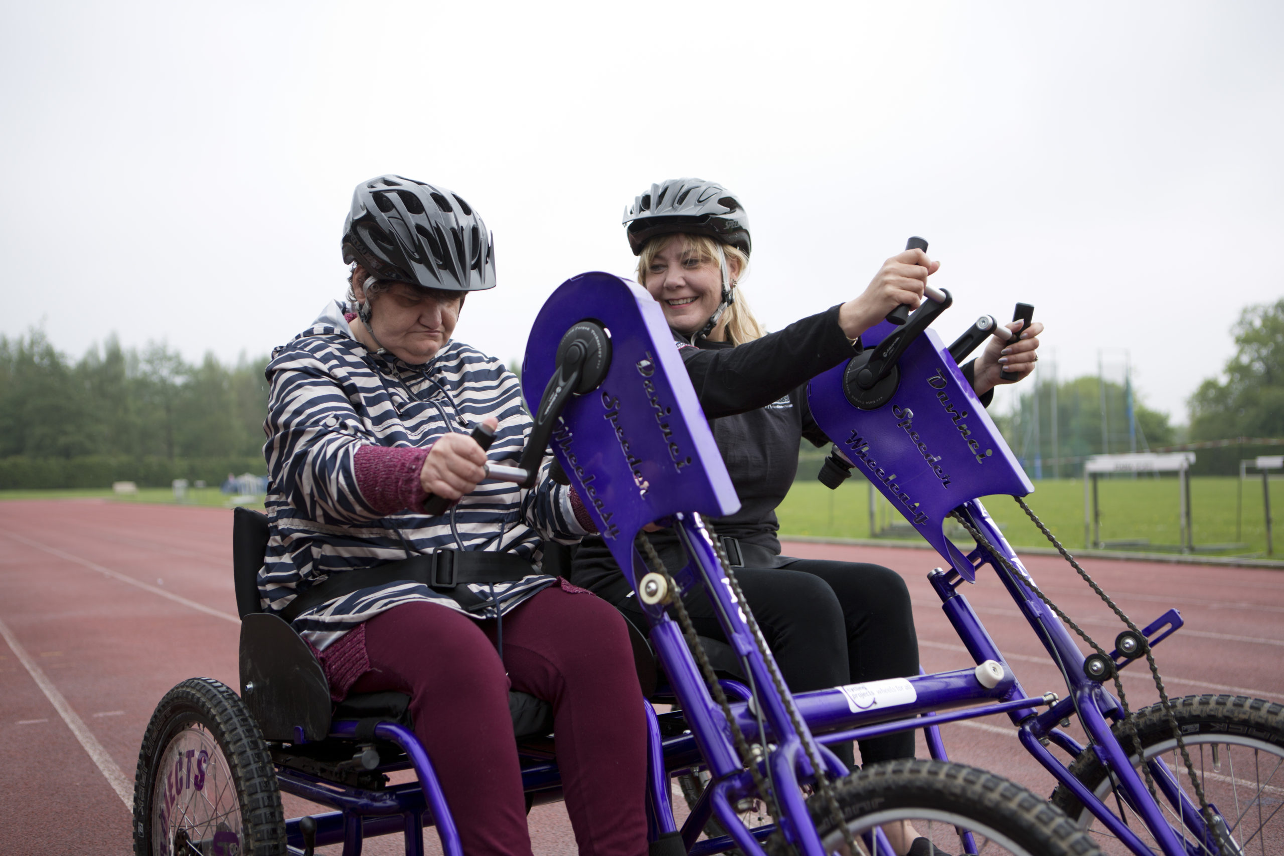 Photo of 2 people cycling side by side.