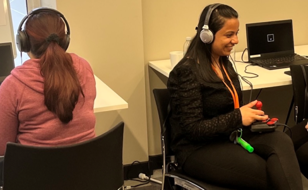 A couple of young women testing an audio only computer game.