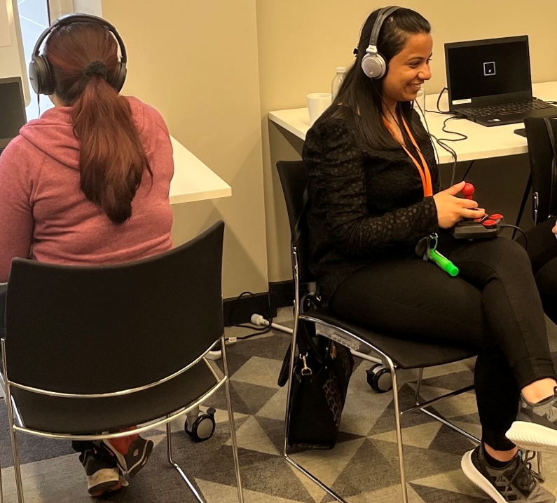 A couple of young women testing an audio only computer game.
