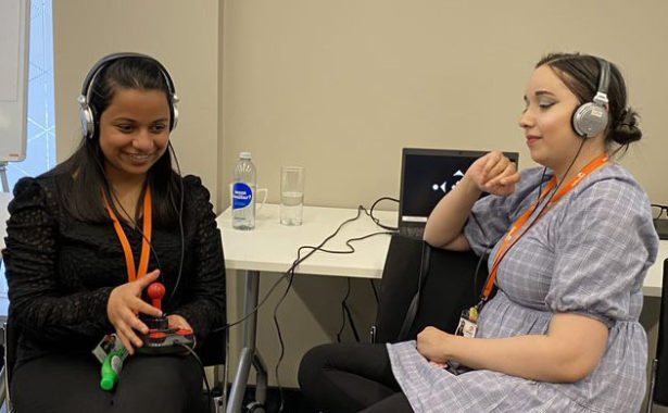 Nadia Patel (Learning and Skills Co-ordinator, Galloways Society for the Blind) and Fatima Rifai (Support Assistant, Galloway's Society for the Blind). Nadia plays the audio game with a joystick controller, while Fatima listens in, via headphones. Copyright: Lancaster University.