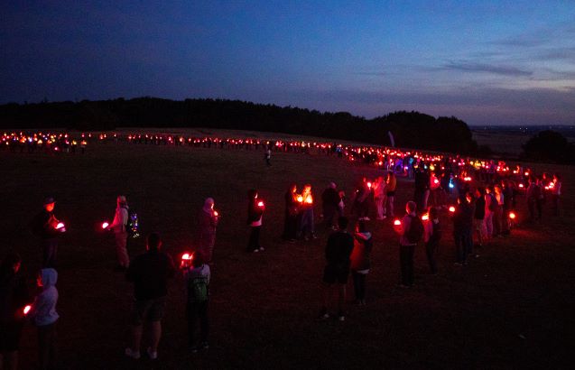 Pretty lights against the night sky created by a crowd of people on Dunstable Downs at night holding Geolights.