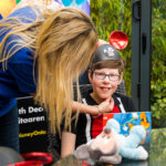 Young person smiling and wearing Mickey Mouse ears