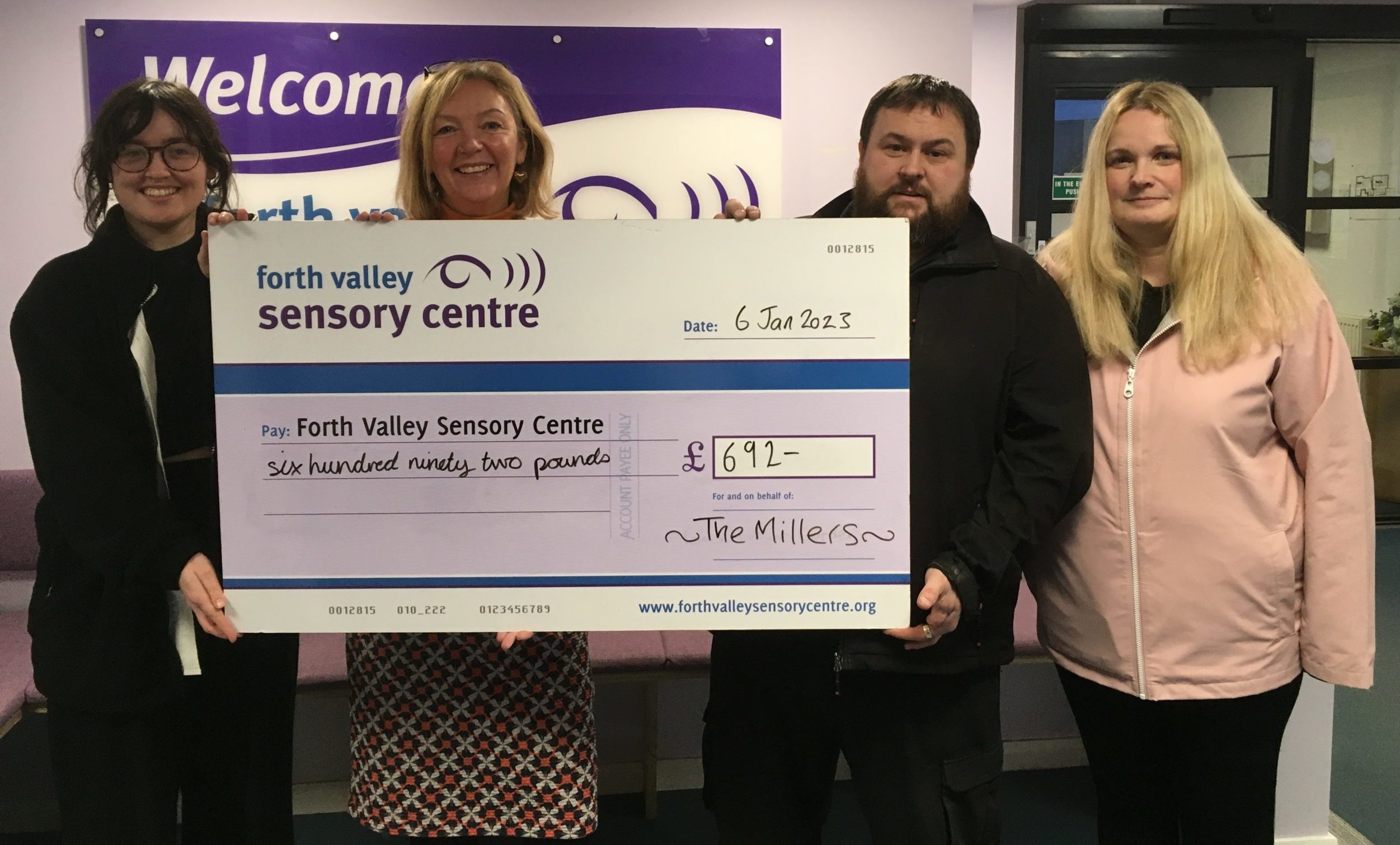 (L-R): Sara Burns, FVSC’s energy adviser, Jacquie Winning, chief executive of FVSC, Gordon Miller and Pamela Miller holding a large cheque to Forth Valley Sensory Centre for £692.