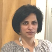 Sonali wearing a brown top and silver necklace.