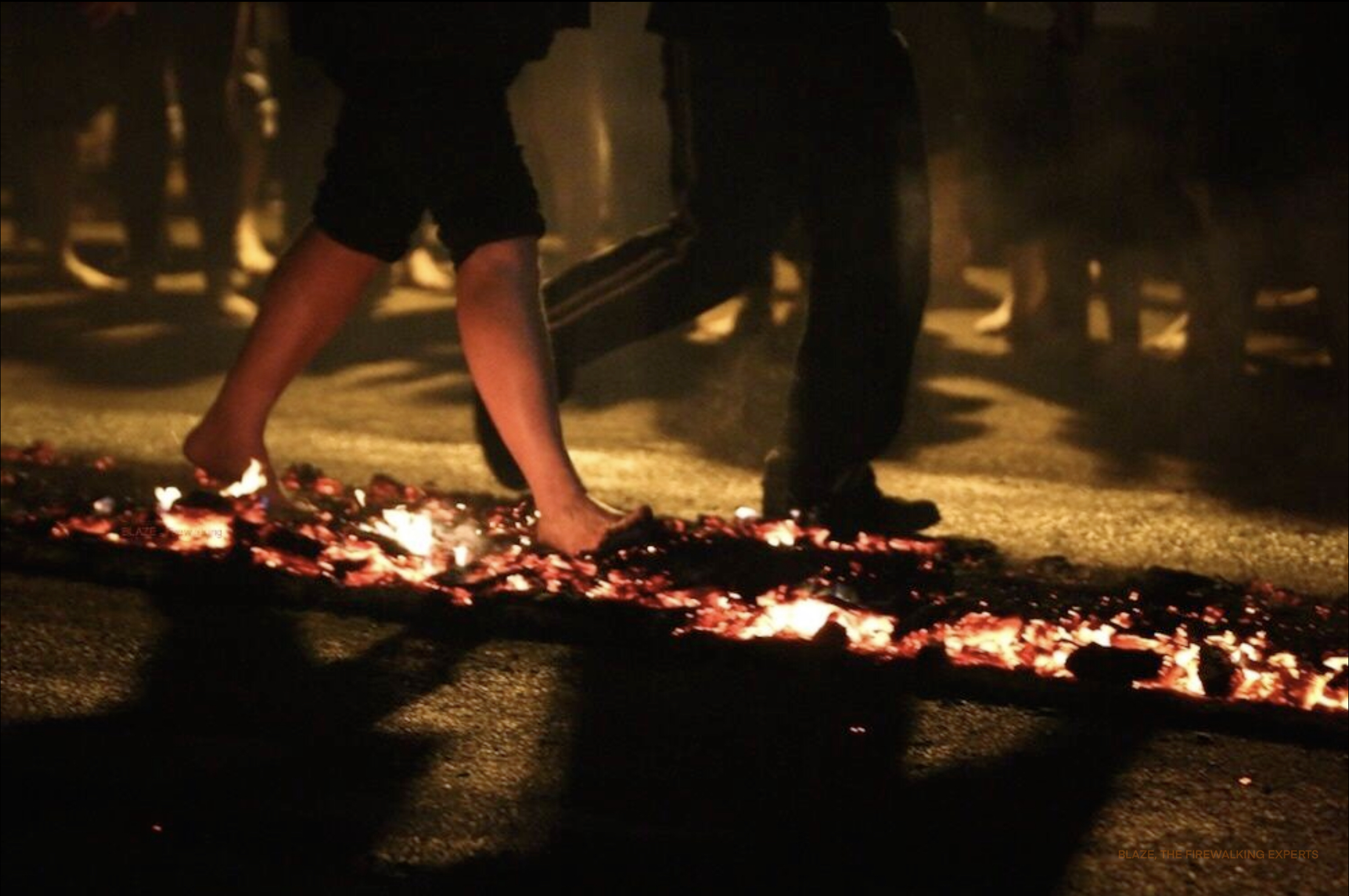 A person walking bare foot along burning coals and embers.