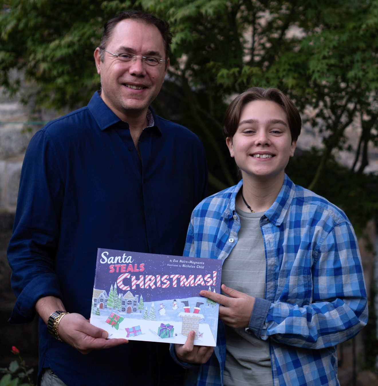 Mark and Eve holding the book "Santa Steals Christmas".