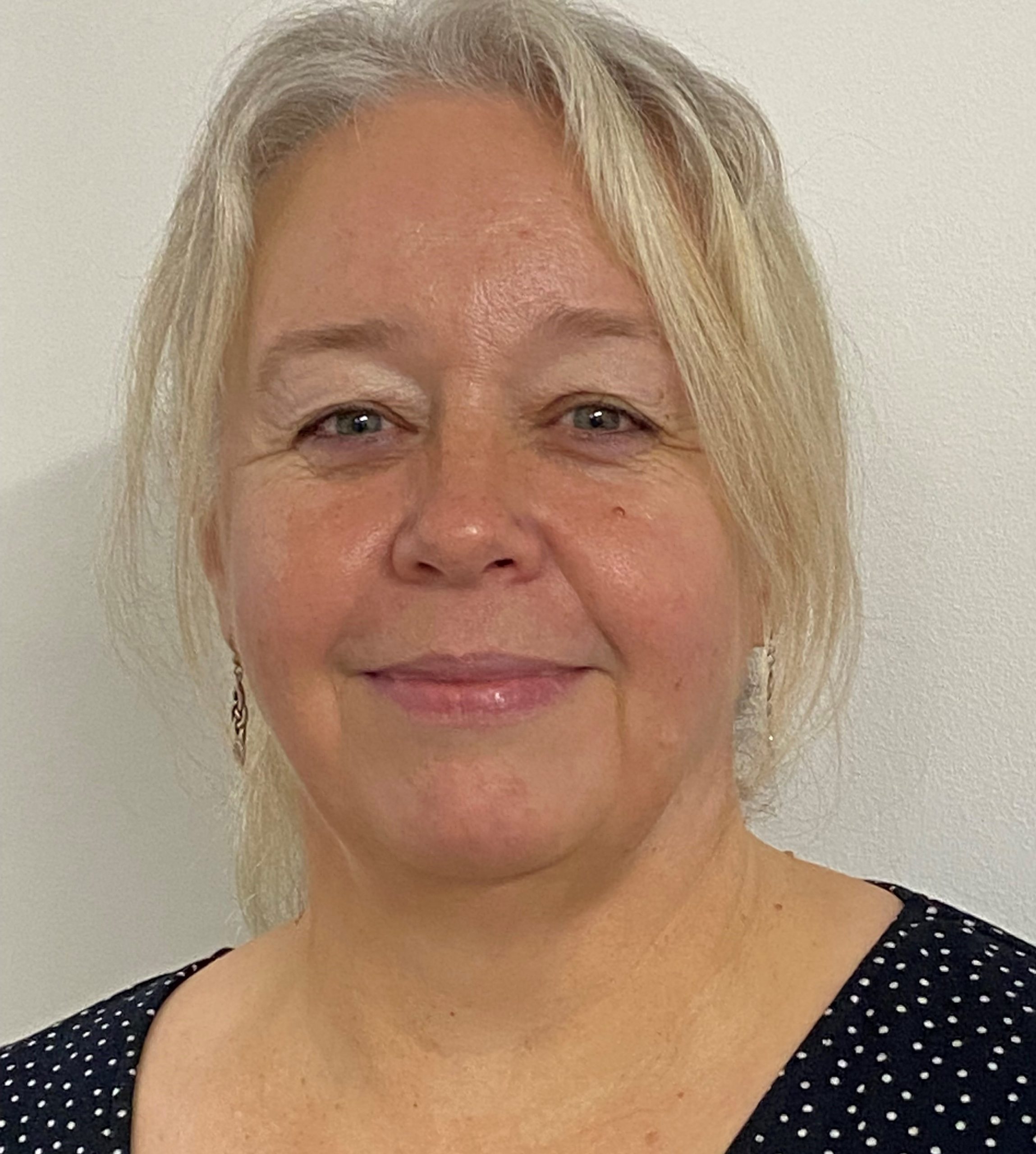 Beccy Iddon, smiling wearing a black top with white dots.