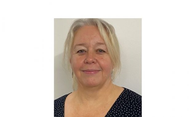 Beccy Iddon, smiling wearing a black top with white dots.