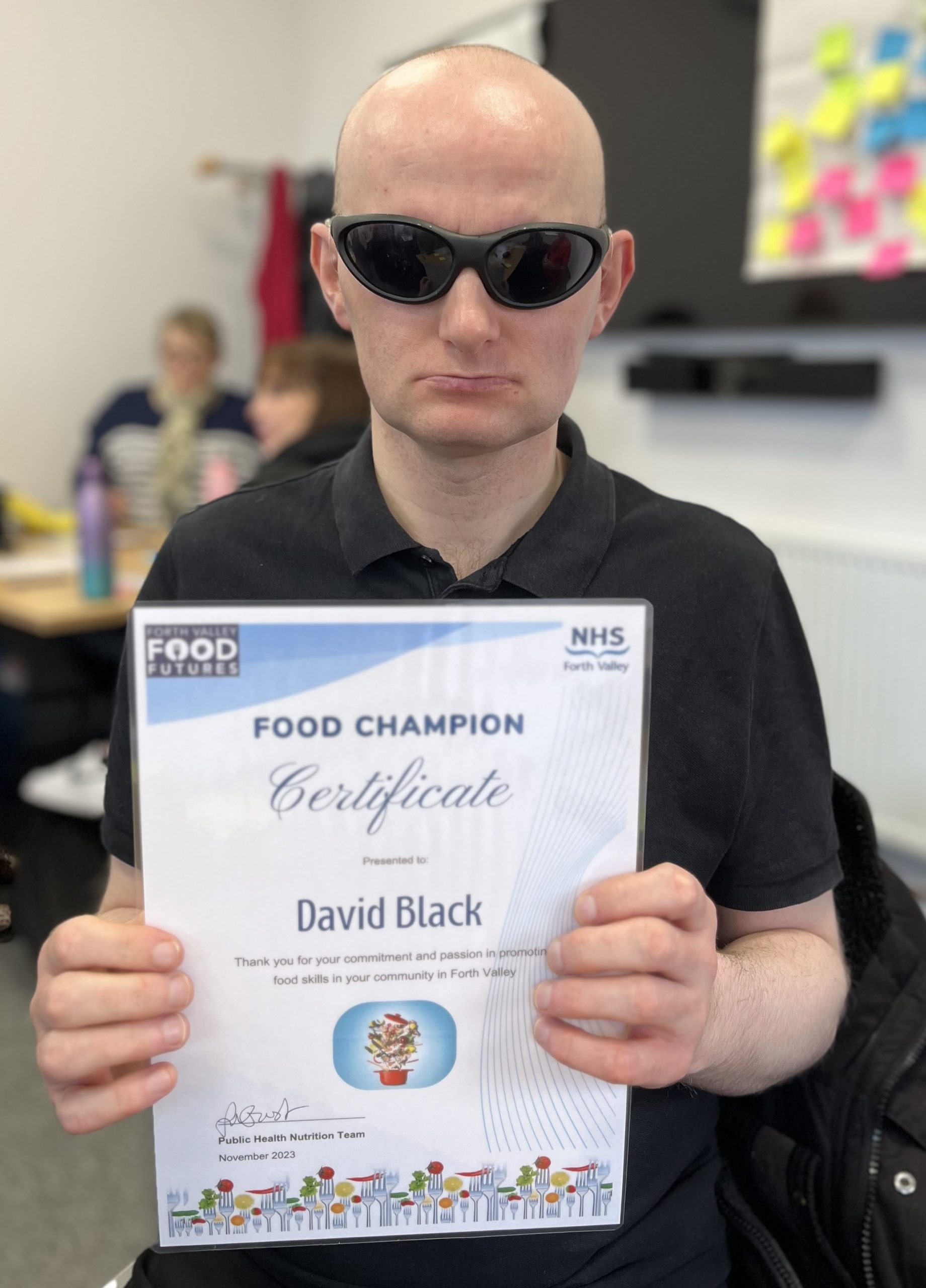 David holding up his Food Champion certificate.