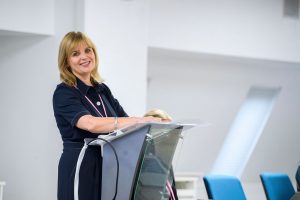 Fiona standing at a podium smiling 