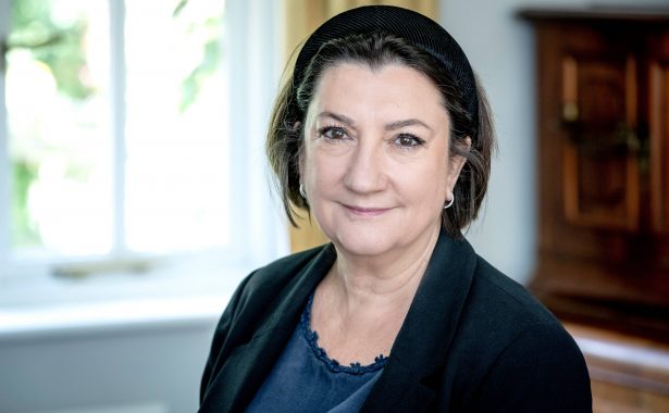 Cathy Yelf smiling, wearing a blue top and black blazer.