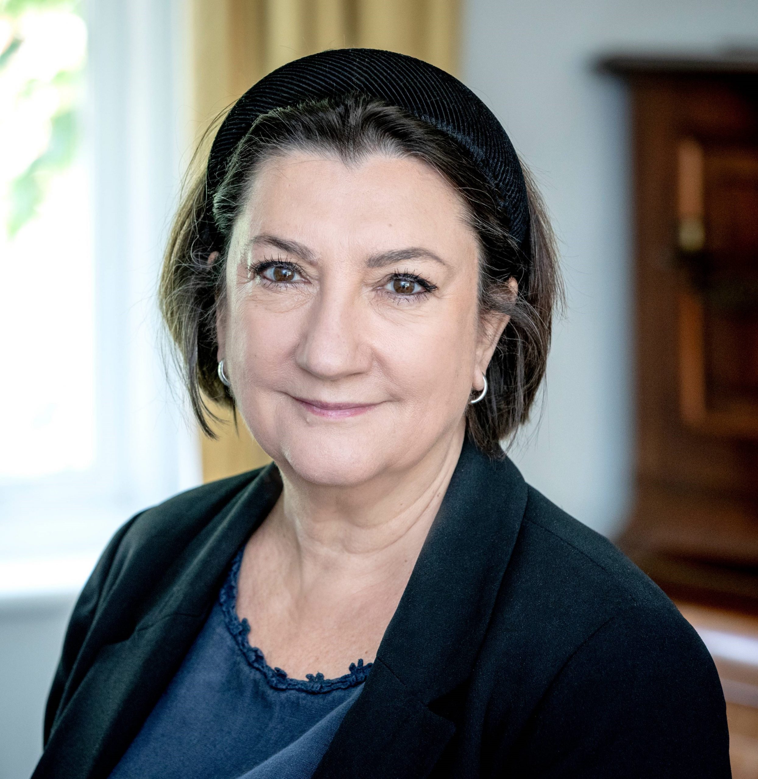 Cathy Yelf smiling, wearing a blue top and black blazer.