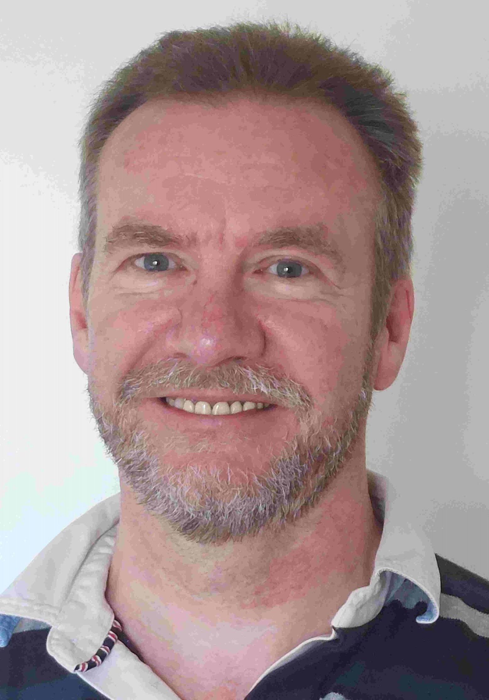 Kenneth Auld smiling, wearing a rugby shirt.