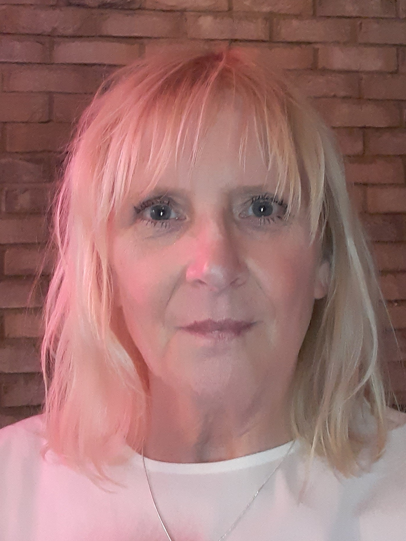 Lorraine Storey is wearing a white top, and has a blonde bob.