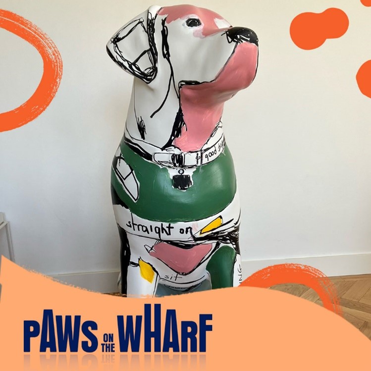 Graphic with the Paws on the Wharf logo and a front view image of a decorated guide dog sculpture, painted with green, grey and pink with black markings. The words such as 'straight on' are painted across the dog's body.