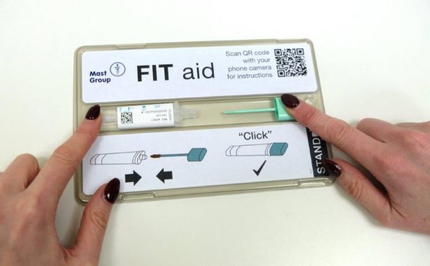 FIT kit with hands holding the bottle and lid flat in the channel ready to slide together.
