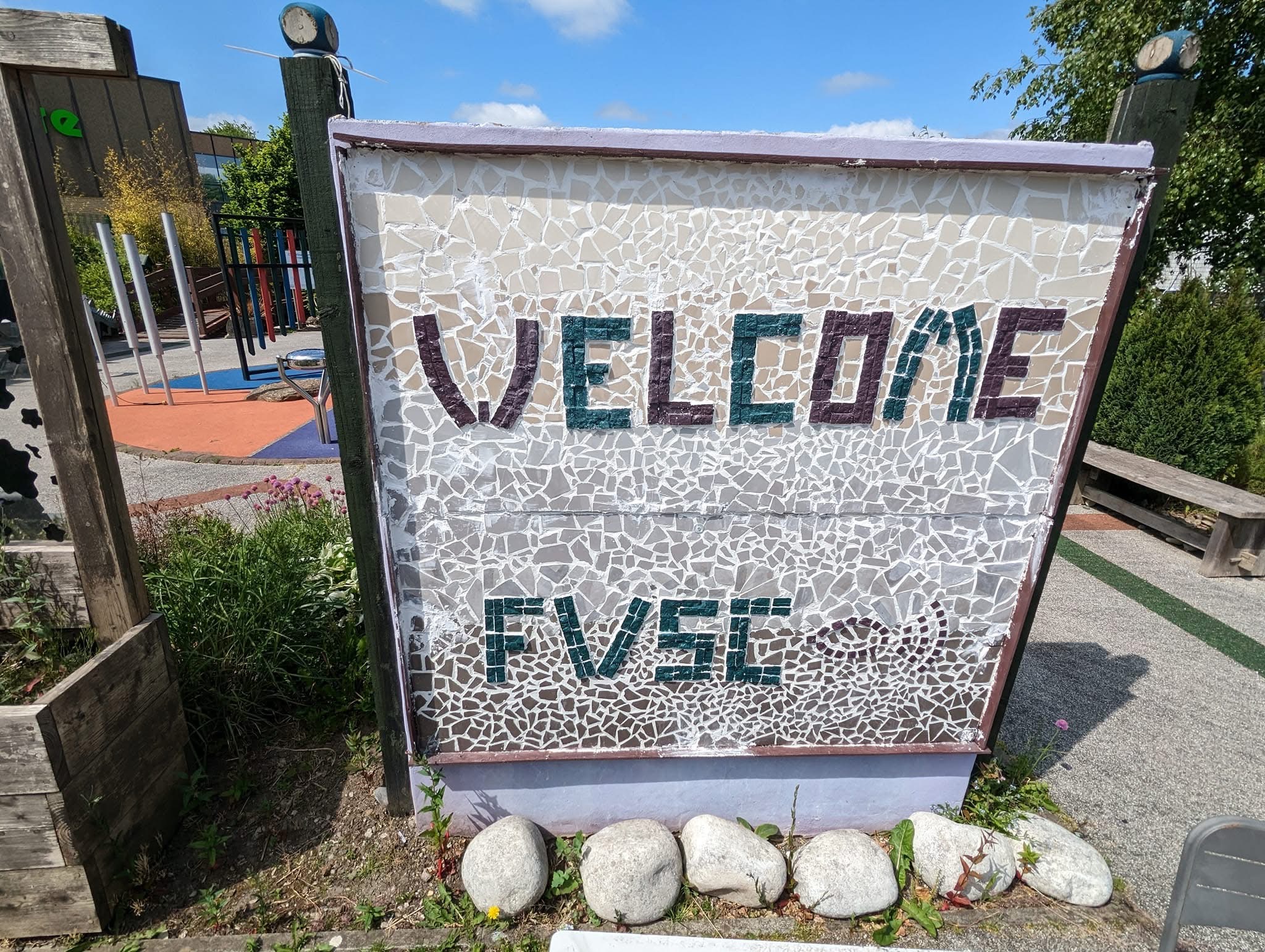 Large, square, tactile, mosaic sign in garden says "Welcome FVSC".