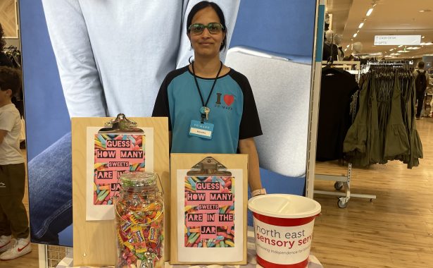 Primark Aberdeen Union Street team member standing in store behind a table, fundraising for NESS.