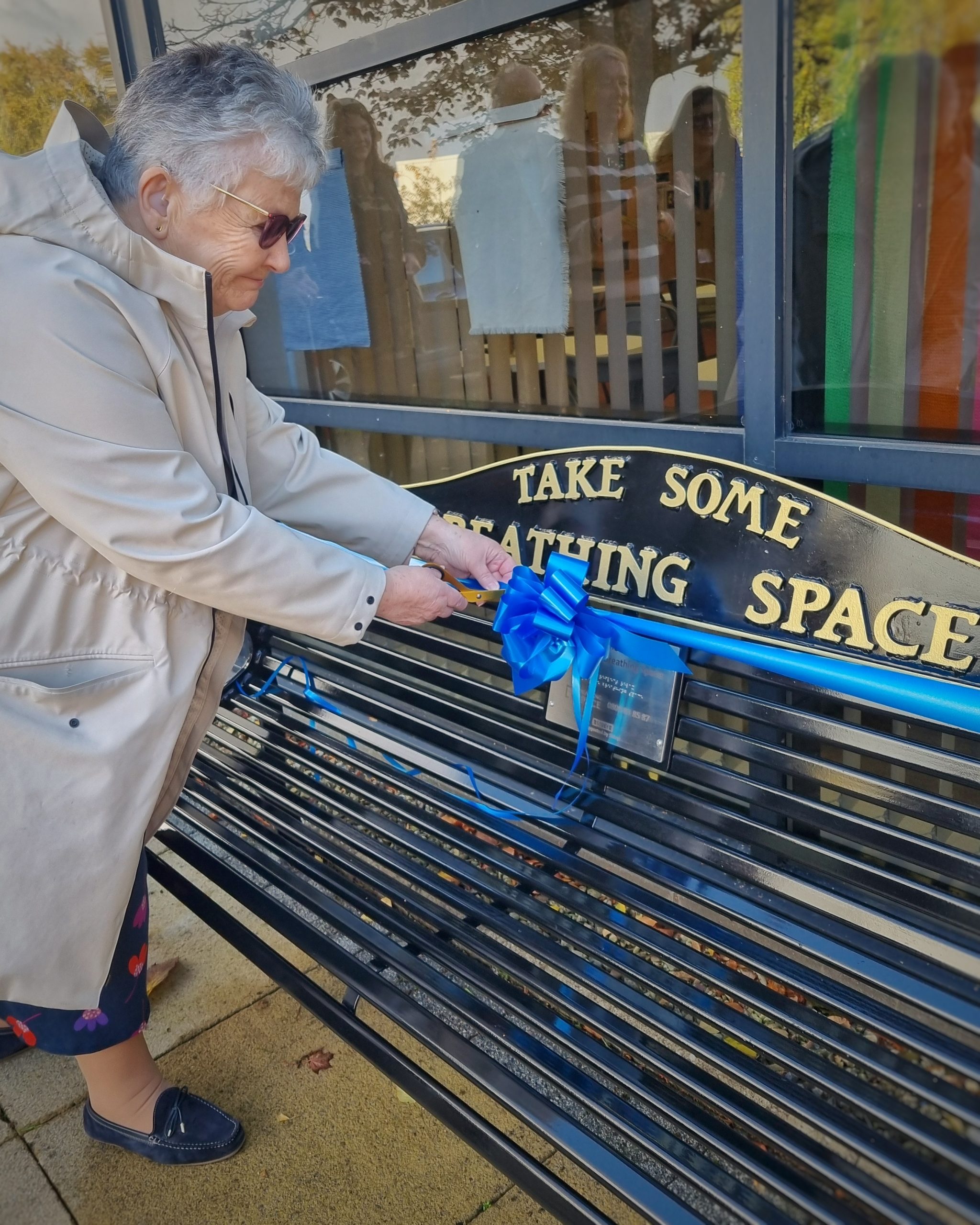 Maureen Smith cuts the ribbon on the Breathing Space bench.