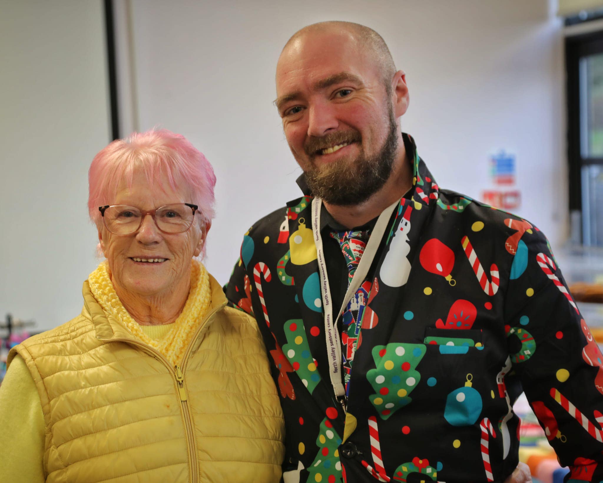 Catherine from The Braveheart Association has short pink hair and is wearing yellow and Forth Valley Sensory Centre's Jamie McKay is wearing a festive Christmas top.