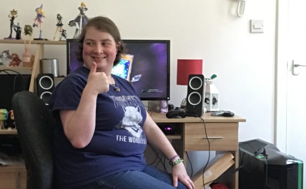 Kellie Dingwall sitting at her gaming desk gives a thumbs up.