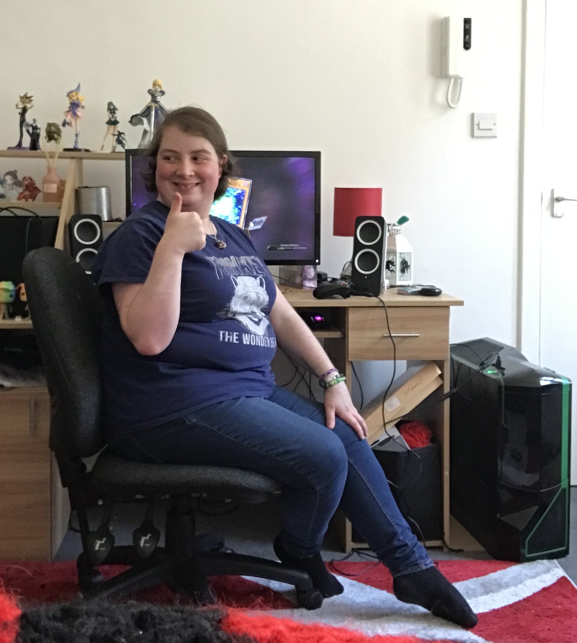 Kellie Dingwall sitting at her gaming desk gives a thumbs up.