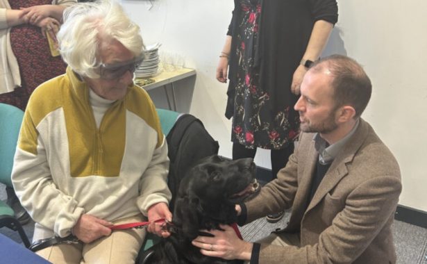 Stephen Gethins MP with a NESS service user patting her black dog.