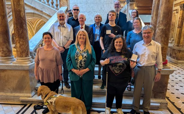 Group photo, participants holding medals. Bottom row left to right: Jen Worral (participant, with guide dog Snowball), Lord Provost, Claire Forde (participant), John McArthur (Glasgow Speakers Club), middle row: James Adams (Director, RNIB Scotland), Cllr Robert Mooney (sponsor), Luke Teasdale (participant), Morag Wilson (participant), Back row: Robert King (participant), Grace Hendry-Nash (Glasgow Speakers Club), Bobby Livingston (GSC), and Iona Adamson (RNIB Scotland volunteer).