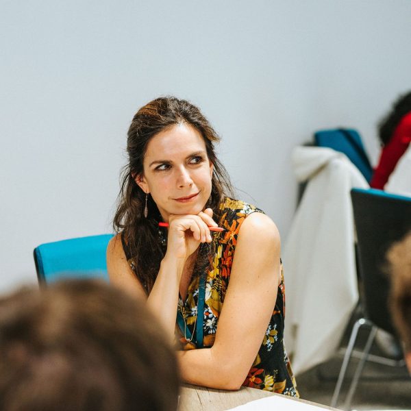 A conference delegate looking thoughtful, seated at a workshop table