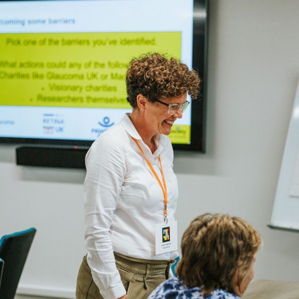 Workshop facilitator from 2025 conference, standing at a workshop table