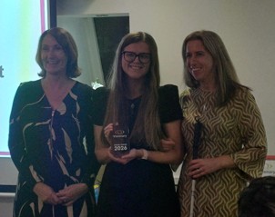 Cathy Low from Thomas Pocklington Trust is smiling, standing next to Charlotte Milburn from LOOK UK who is holding a trophy. Charlotte Carson from LOOK UK is on the far right.
